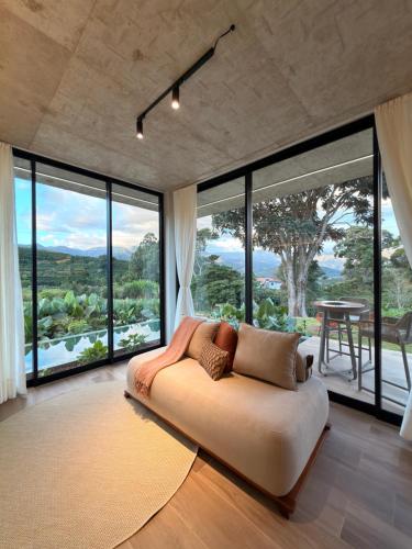 a large living room with a couch and large windows at Casa Cedro II in Espera Feliz