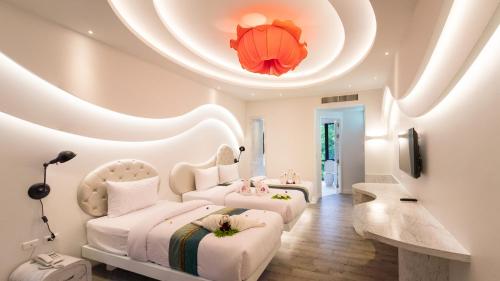 two beds in a bedroom with a circular ceiling at Avatara Resort in Ko Samed