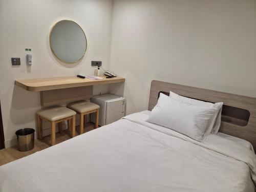 a bedroom with a white bed and a mirror at 광장관광호텔 in Pusan