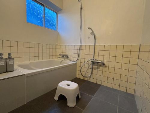 a bathroom with a tub and a toilet in it at Seven base Yoshiumi in Imabari