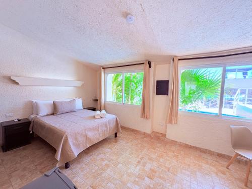 a bedroom with a bed and a large window at Condohotel Luciana Deluxe Queen Oceanview Suite with Sofabed in Playa del Carmen