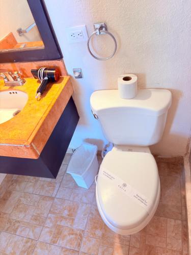 a bathroom with a white toilet and a sink at Condohotel Luciana Deluxe Queen Oceanview Suite with Sofabed in Playa del Carmen