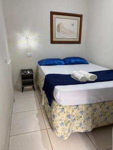 a bedroom with a bed with blue and white sheets at Pousada brandt Ap 3 in Campo Grande