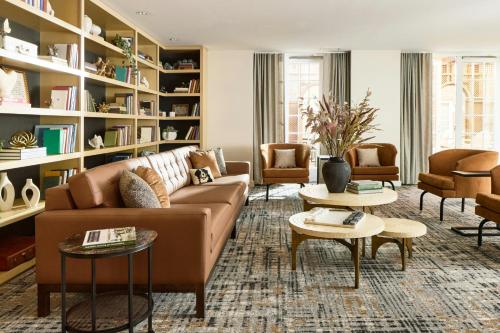 a living room with a couch and chairs and tables at Archer Hotel Old Town Alexandria in Alexandria