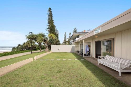 a house with a lawn in front of a building at Little Waves Tugun in Gold Coast