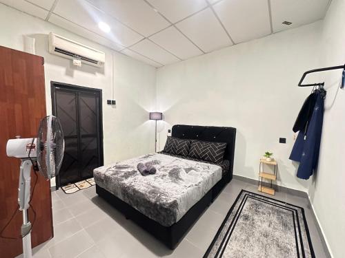 a bedroom with a bed and a fan at Ellhavfiz Homestay in Tapah