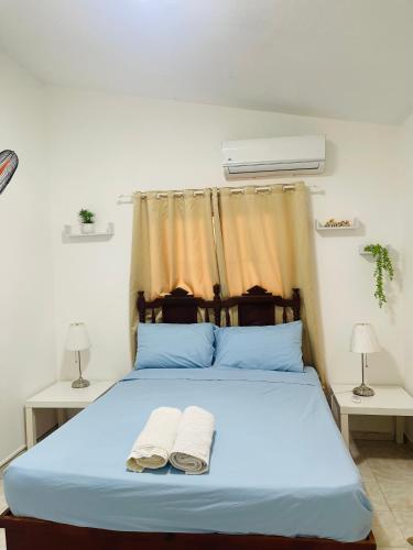 a bedroom with a blue bed with two towels on it at Estancia Dulce Hogar, en pedernales in Pedernales