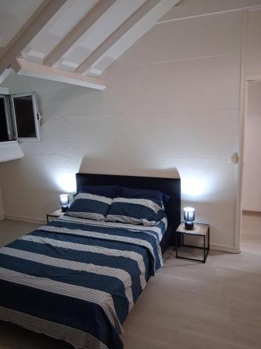 a bedroom with a bed with blue and white stripes at La terrasse in Baie-Mahault