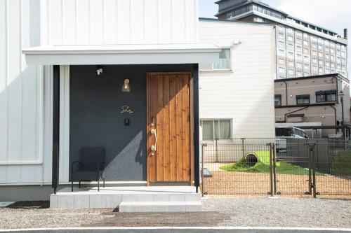 a wooden door on the side of a building at Shiro in Hakodate