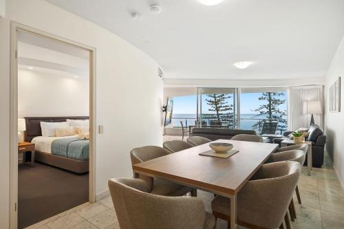 a living room with a dining table and a bedroom at Sirocco 507 by G1 Holidays in Mooloolaba