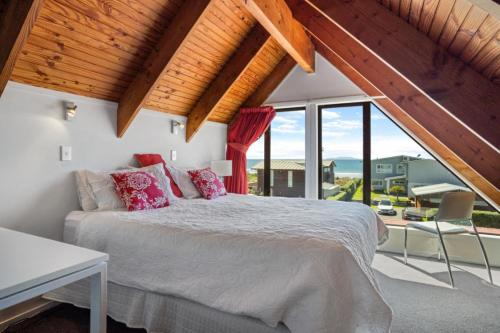 a bedroom with a bed and a large window at Tangaroa Beachside Bliss - with Private Pool in Whangamata