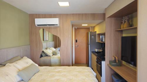 a small bedroom with a bed and a television at Studio Beira-Mar na Praia dos Carneiros in Tamandaré