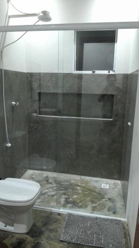 a bathroom with a glass shower with a toilet at Chalé aconchego sfx in São José dos Campos