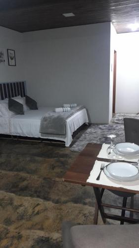 a bedroom with a bed and a table with plates on it at Chalé aconchego sfx in São José dos Campos