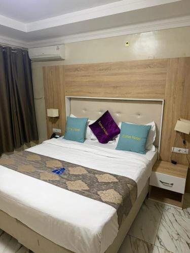 a bedroom with a large bed with purple and blue pillows at Hôtel Esma Nouadhibou in Nouadhibou