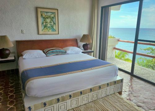 a bedroom with a bed with a view of the ocean at Condumel in Cozumel