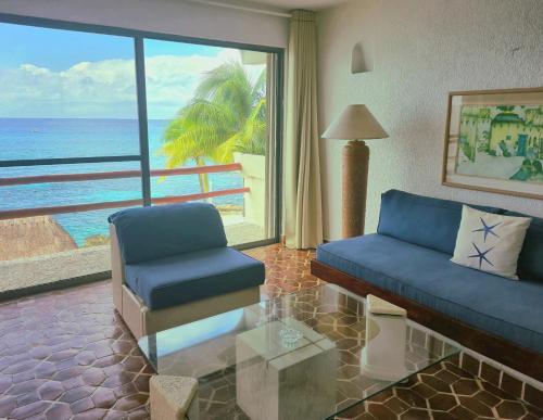 a living room with a couch and a view of the ocean at Condumel in Cozumel
