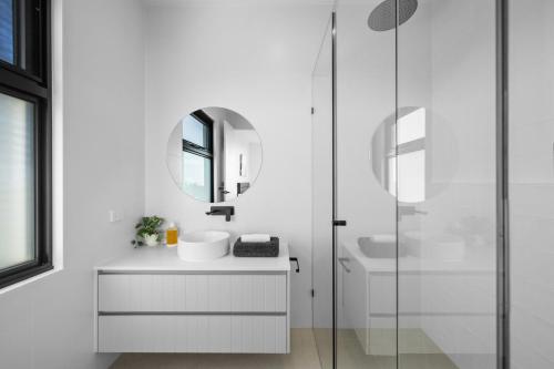 a white bathroom with a sink and a mirror at Island View San Remo in San Remo