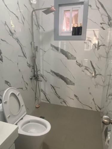 a bathroom with a white toilet and a sink at Mira Transient in Bantay