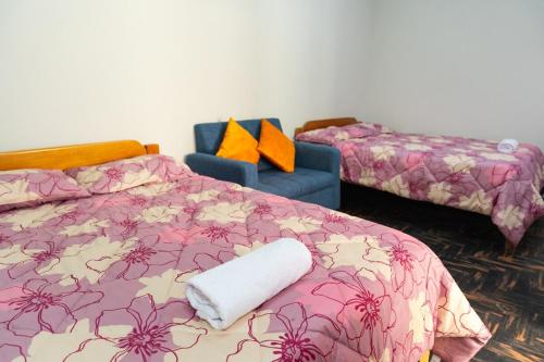 a bedroom with a bed and a blue chair at Comfortable apartment in Urubamba in Urubamba