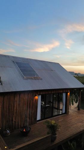 a house with a solar panel on the roof at Chalé romântico com jacuzzi e vista do pôr-do-sol in Harmonia