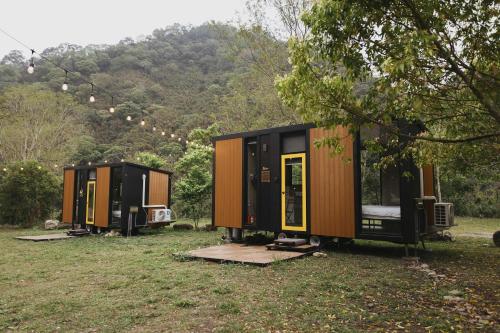 three tiny houses are parked in a field at Lanyin Hut in Shui-t'ien