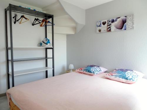 a bedroom with a bed with two pillows on it at Stone House in Bricqueville near Sandy Beach in Bricqueville-sur-Mer