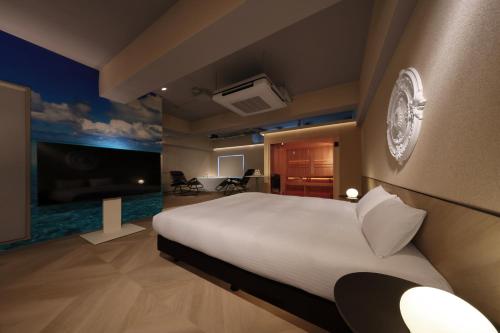 a bedroom with a large white bed in a room at クリスタルサウナ in Miyako-jima