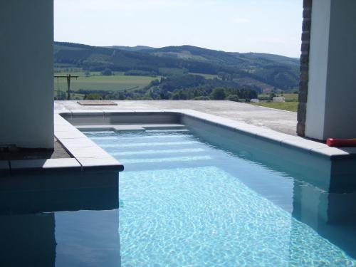 ein Schwimmbad mit Blick auf die Berge in der Unterkunft Villa Les Charmes Premium villa for 20 guests in Habiemont