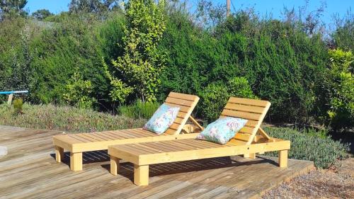 two wooden benches sitting on a wooden deck at Lily Home in Algarrobo