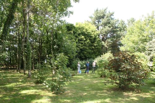 a group of people walking down a path in a park at Logis Latitude Ouest Hôtel Restaurant & Spa in Locronan