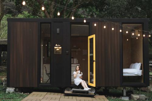 a woman is sitting in a tiny house at Lanyin Hut in Shui-t'ien