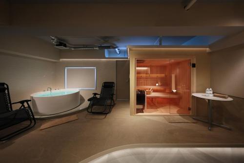 a room with a bath tub and a table and a table at クリスタルサウナ in Miyako-jima