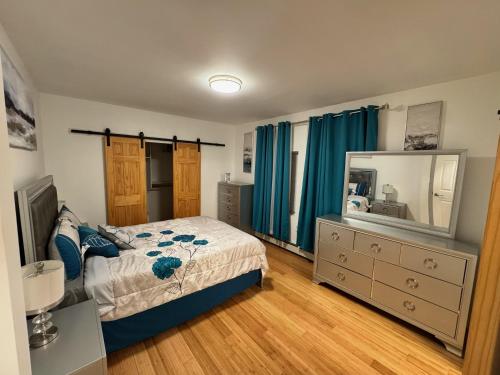 a bedroom with a bed and a dresser and a mirror at Bright & Comfortable Home in the Heart of It All in Central Islip