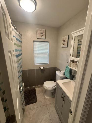 a bathroom with a toilet and a sink and a mirror at Bright & Comfortable Home in the Heart of It All in Central Islip