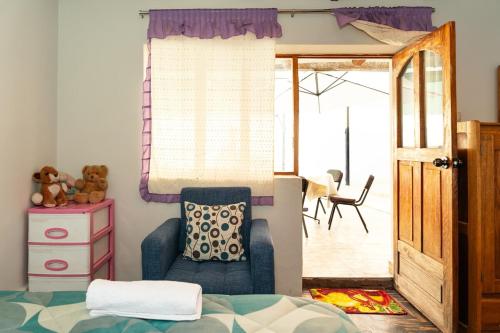 a bedroom with a bed and a chair and a door at Perfect Rest in Urubamba in Urubamba