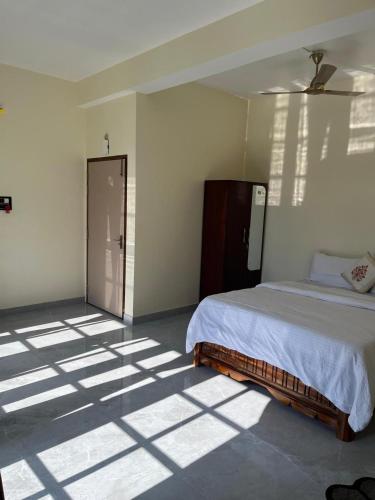 a bedroom with a bed and a room with a door at Janaa Residence in Dithur