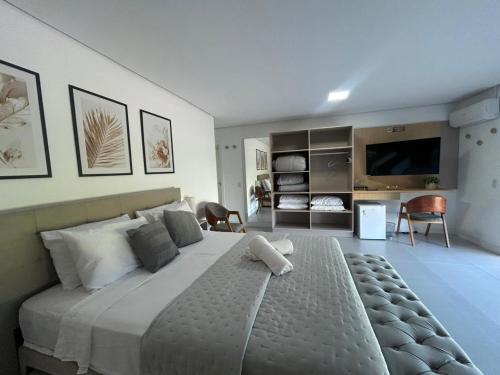 a large bedroom with a large bed and a television at Esplendor Residence Seu Paraíso em Atlântida com Piscina in Xangri-lá