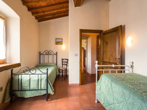 a bedroom with two beds and a table and chairs at Mansion with Pool and play area in Pian di Scò