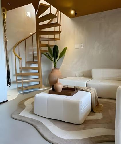 a living room with a white couch and a staircase at Naay - Sun 008 in Pôrto de Pedras