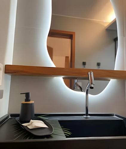 a kitchen counter with a sink and a mirror at Naay - Sun 008 in Pôrto de Pedras