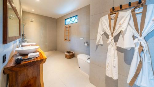 a bathroom with a sink and a toilet and a mirror at Sea Sun Beach Villa in Nusa Lembongan