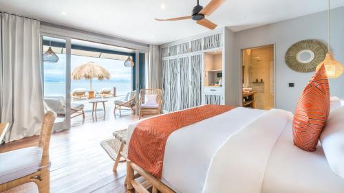 a bedroom with a large bed and a dining room at Sea Sun Beach Villa in Nusa Lembongan