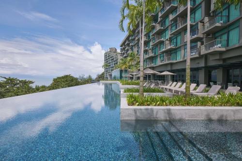 a swimming pool in front of a building at Angsana Teluk Bahang, Penang in Batu Ferringhi