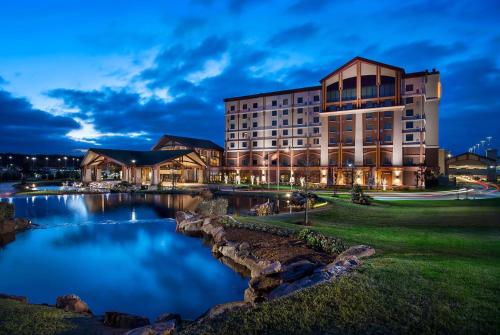 a building with a pond in front of it at Choctaw Casino & Resort Pocola, Trademark Coll by Wyndham in Pocola
