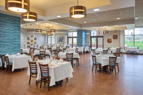 a dining room with white tables and chairs at Choctaw Casino & Resort Pocola, Trademark Coll by Wyndham in Pocola