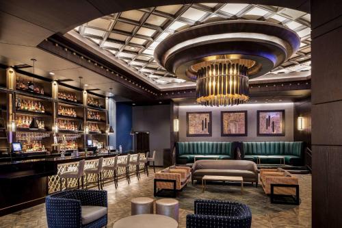 a bar with a green couch and chairs and a chandelier at Choctaw Casino & Resort Durant, a Wyndham Grand Hotel in Durant