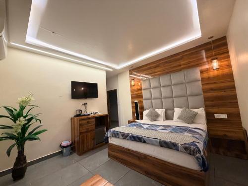 a bedroom with a large bed and a television at Landlord Premier in Rohtak