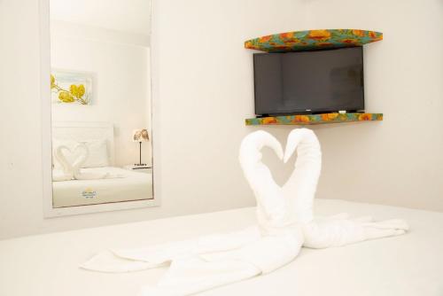 a towel swan in front of a mirror at Pé na areia - verdadeiro paraíso em Muro Alto in Porto De Galinhas