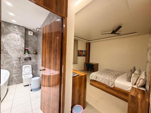 a bedroom with a bed and a bathroom at Landlord Premier in Rohtak